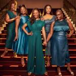 The Muses from Disney's Hercules standing on the stairs at Theatre Royal Drury Lane, wearing teal and green dresses.